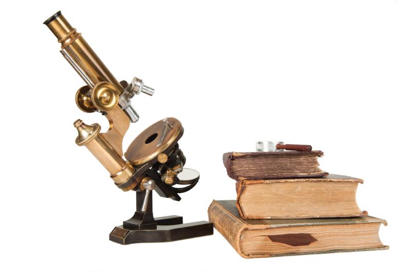 A microscope and a pile of books. Certain Minute Creatures, AIBN's Small Things Big Changes.