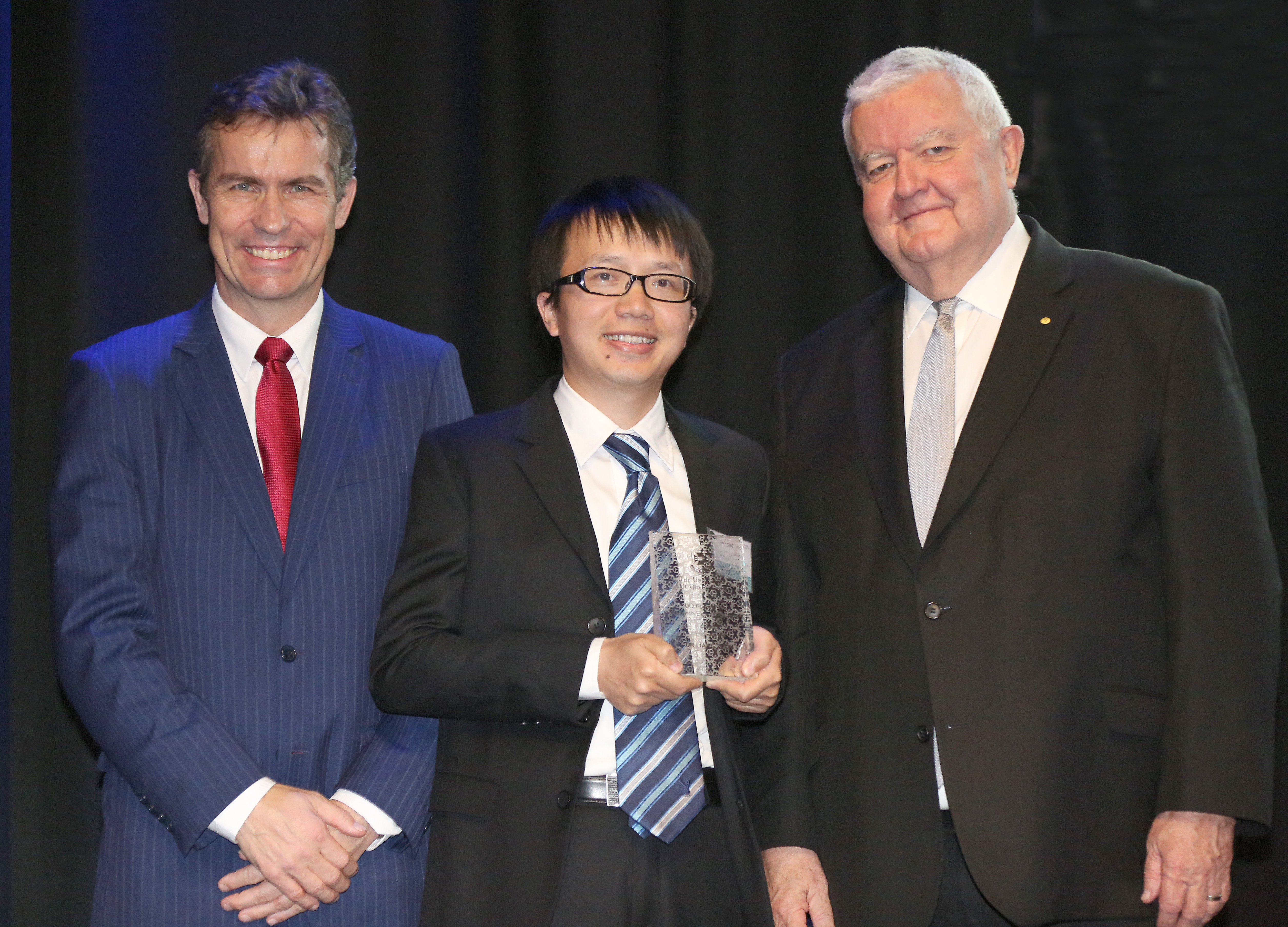 AIBN Dr Liang Zhou receiving his FREA from UQ’s Vice-Chancellor and President Professor Peter Høj (left) and Australia’s chief scientist, Professor Ian Chubb (right)